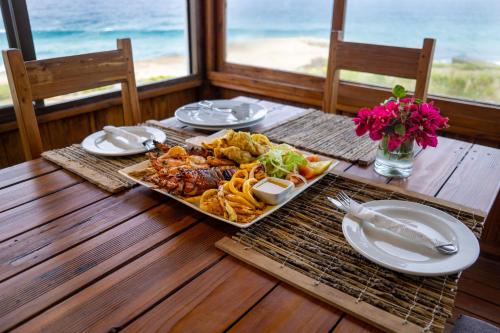 uma mesa com uma bandeja de comida numa mesa de madeira em C-Mew Guest House em Praia do Tofo