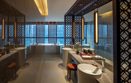 重慶的住宿－重庆丽晶酒店，洲际酒店集团旗下，浴室配有4个盥洗盆、浴缸和浴缸。