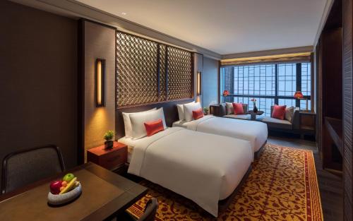 a hotel room with a bed and a desk and a room at Regent Chongqing - Complimentary 1st round mini bar daily in Chongqing