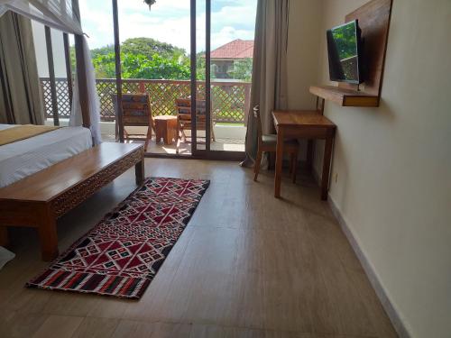 a bedroom with a bed and a rug on the floor at Zanzibar Star Resort in Nungwi