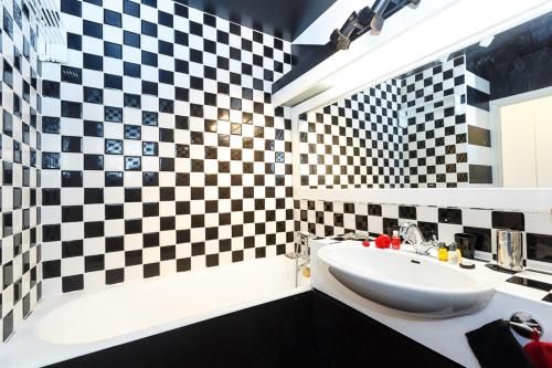 - une salle de bains avec du carrelage en damier noir et blanc dans l'établissement B&B Junior Suite Paris Tour Eiffel, à Paris