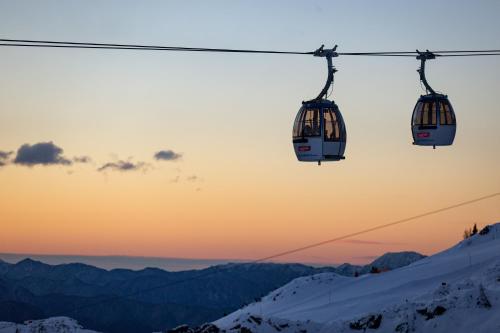 a pair of ski lifts flying over a snow covered mountain at Clofers Leisure Lodges Jenig in Jenig