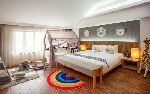 Lin Yin Art Hotel Shanghai（Pudong airport） في شانغهاي: غرفة نوم بسرير مظلة وزرافة