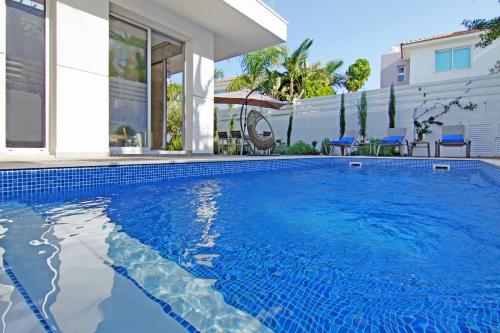 una piscina davanti a una casa di Villa Lily a Protaras