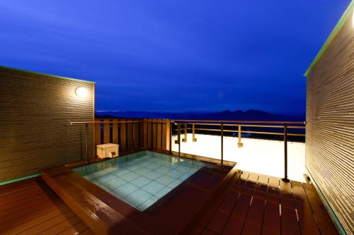 a hot tub on a deck at night at Mimatsukan in Shibukawa