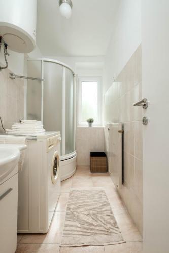a bathroom with a washing machine and a sink at Periva Apartment Zagreb in Zagreb