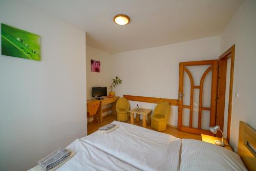 a bedroom with a bed and a desk with a computer at Penzion Fantazia Poprad - Self check-in in Poprad
