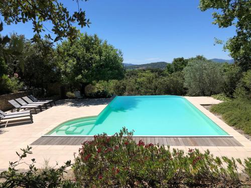 una piscina en un jardín con sillas y árboles en Le Mas du Rocher, en Mérindol-les-Oliviers