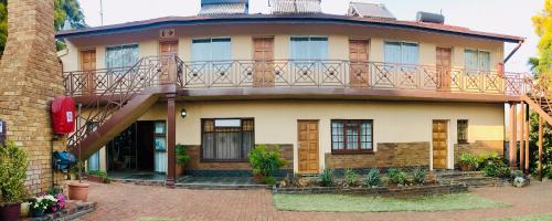 a house with a balcony on top of it at Clubview Guest House in Centurion