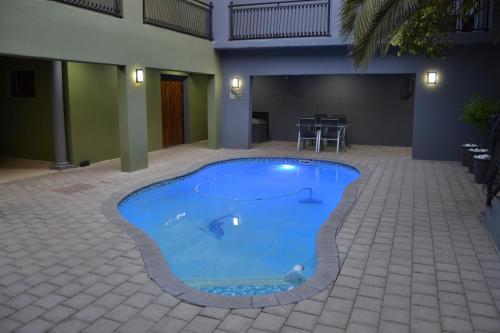 a swimming pool in the middle of a courtyard at African Sands Guesthouse LOAD SHEDDING FREE in Bloemfontein