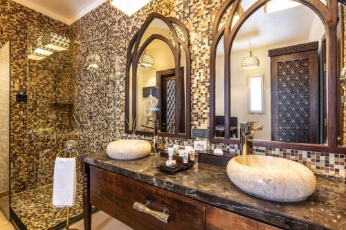 a bathroom with two sinks and a large mirror at Riu Palace Zanzibar - All Inclusive in Nungwi