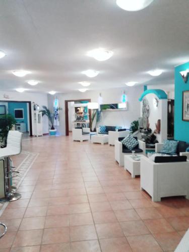 a waiting room with white couches and blue walls at I Ginepri Hotel in Cala Gonone
