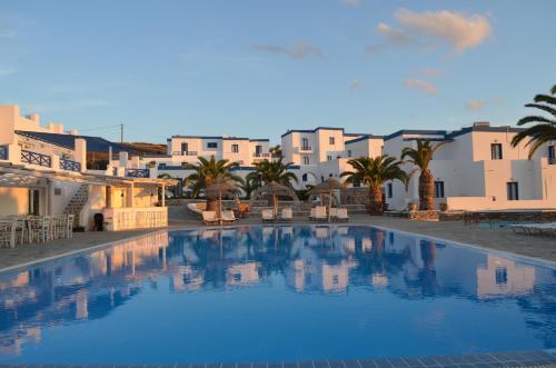 a large swimming pool with buildings in the background at Faros Resort in Azolimnos