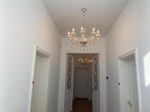 a hallway with a chandelier in a white room at Hotel St. Hubertus in Wallmerod