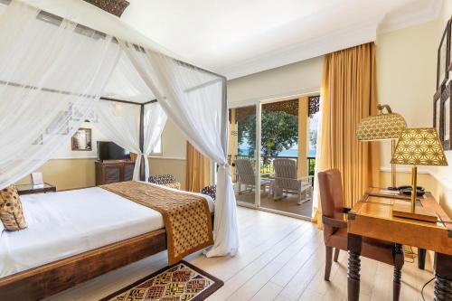 a bedroom with a bed and a desk and a desk at Riu Palace Zanzibar - All Inclusive in Nungwi