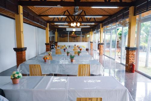 una fila de mesas en una habitación con manteles blancos en La Solana Suites and Resorts by Cocotel, en Puerto Galera