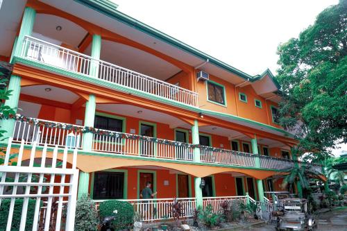 un edificio naranja con balcones blancos. en La Solana Suites and Resorts by Cocotel, en Puerto Galera