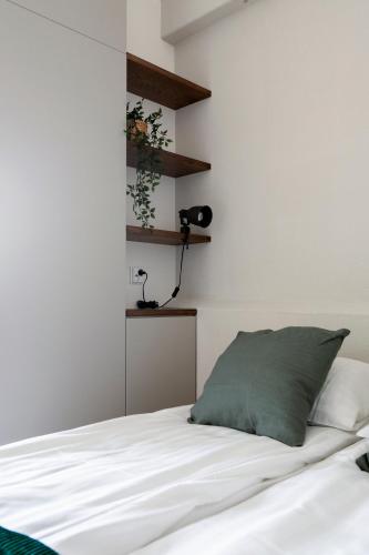 a bedroom with a white bed with a green pillow at 2ndhomes Ullanlinna Penthouses 2 in Helsinki
