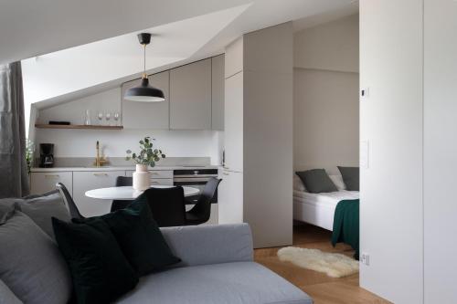 a living room and kitchen with a couch and a table at 2ndhomes Ullanlinna Penthouse Apartments 2 in Helsinki