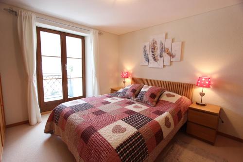 1 dormitorio con 1 cama con 2 lámparas y una ventana en Rosat 13, en Château-d'Oex