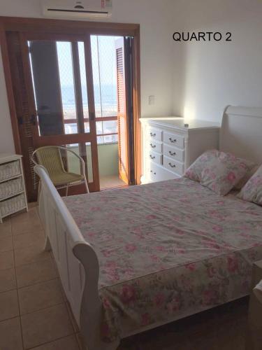 a bedroom with a large bed and a balcony at apartamento 4 praças in Torres