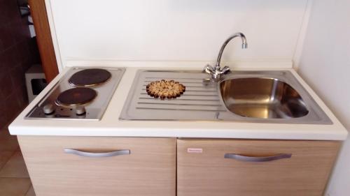 a kitchen with a sink and a stove at Spinnaker in Oristano