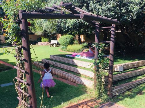 a young girl standing on a lush green park bench at Riverton Manor in Centurion