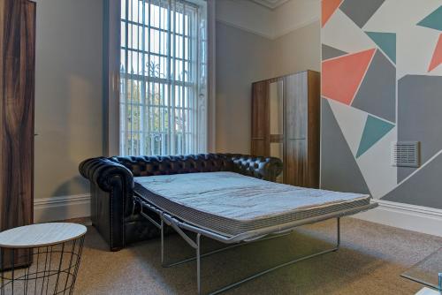 a bed in a room next to a window at Manchesters Ultimate House - Hot tub - Sleeps 23! in Manchester