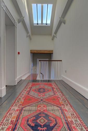 an empty room with a persian rug on the floor at Manchesters Ultimate House - Hot tub - Sleeps 23! in Manchester
