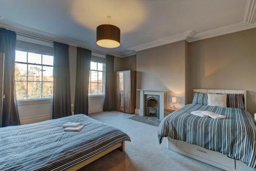 um quarto com uma cama e uma lareira em Manchesters Ultimate House - Hot tub - Sleeps 23! em Manchester