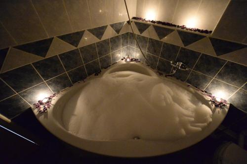 a bath tub in a bathroom with lights at Hotel Slodes in Belgrade