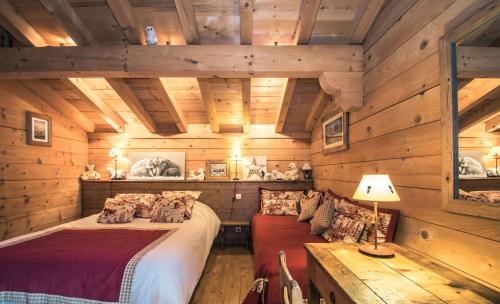 Dormitorio en cabaña de madera con cama y sofá en Chalet Macha, en Chamonix-Mont-Blanc