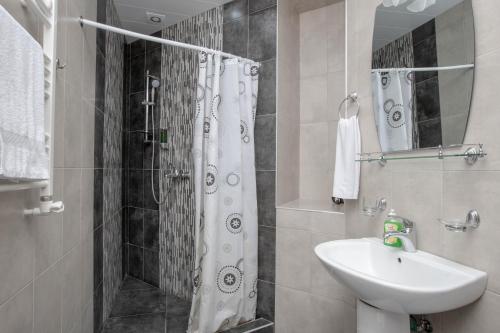 a bathroom with a shower curtain and a sink at Stay Inn Apartments at Mashtots Avenue 5A in Yerevan