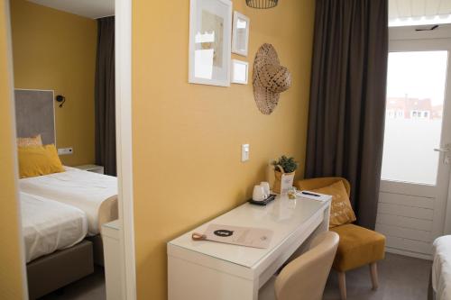 ein Hotelzimmer mit einem Bett, einem Schreibtisch und einem Zimmer in der Unterkunft Hotel Aan Zee in Noordwijk aan Zee