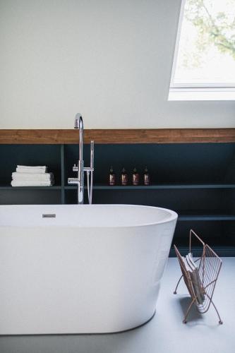 a bathroom with a white tub and a sink at The Annex Retreat - a luxury countryside villa in Geysteren