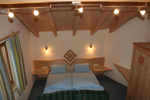 a bedroom with a bed and two desks and lights at Haus Achenrainer in Fiss