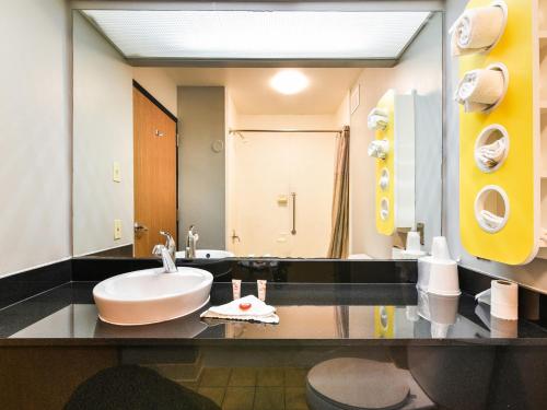 een badkamer met een wastafel en een grote spiegel bij OYO Townhouse Inn Jacksonville near Little Rock Air Force Base in Jacksonville