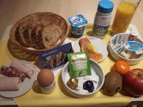 a table topped with a tray of food with eggs bread and fruit at Hapimag Apartments Antibes in Antibes