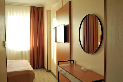 a hotel room with a bed and a mirror at Lion City Hotel Ankara in Ankara