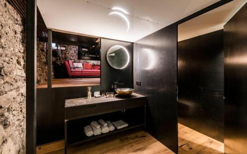 a black bathroom with a sink and a mirror at Flurin Suites in Glorenza