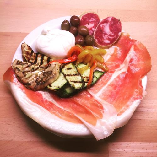 a plate of food with meat and vegetables on a table at La Locanda del Cavaliere in Borgo Montello