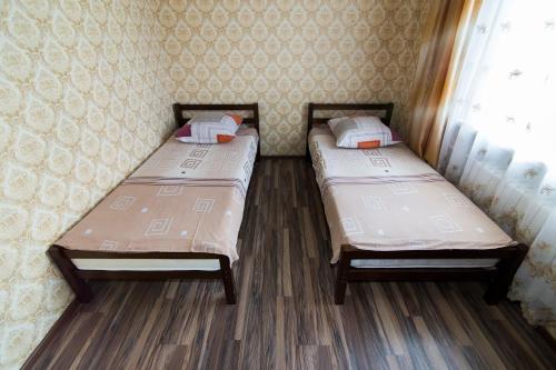 two twin beds in a room with a window at Apartments on Karla Marksa in Mogilev
