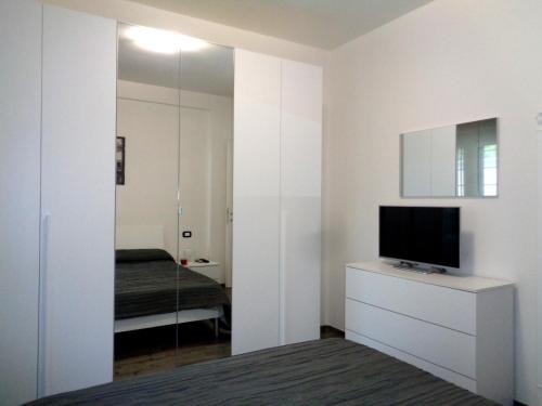 a bedroom with a mirror and a television on a dresser at Caput Mundi Anagina IV in Rome