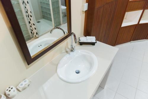 a white bathroom with a sink and a mirror at The Ocean Residence Langkawi in Kuah