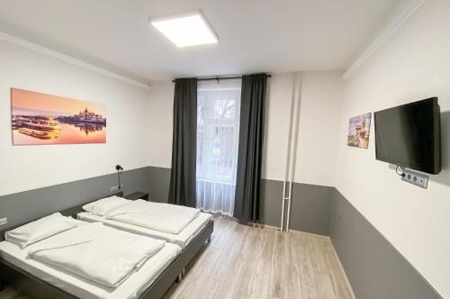 Schlafzimmer mit einem Bett und einem Flachbild-TV in der Unterkunft Dominik Panzió in Budapest
