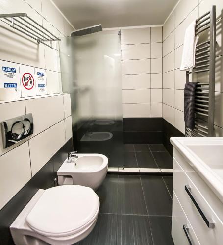 a bathroom with a white toilet and a sink at Dominik Panzió in Budapest