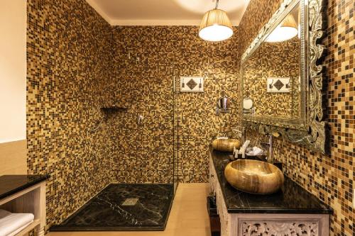 a bathroom with a large gold sink and a mirror at Riu Palace Zanzibar - All Inclusive in Nungwi