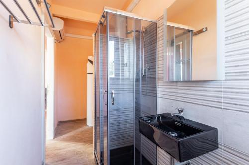 a bathroom with a black sink and a glass shower at Afrodite IdroSuite in Piano di Follo