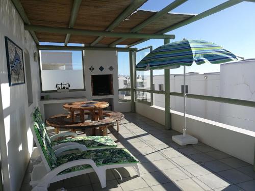 a patio with a table and chairs and an umbrella at Langebaan Paradise Beach Self Catering 5 Elara in Langebaan