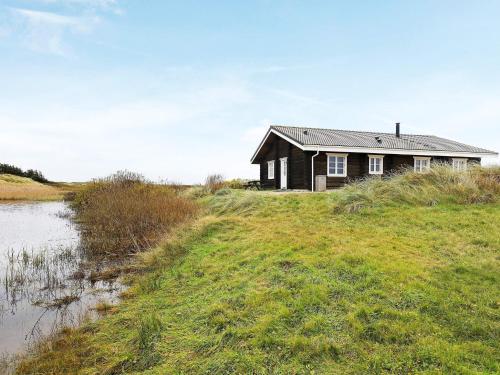 Frøstrupにある10 person holiday home in Fr strupの水の横の畑黒家